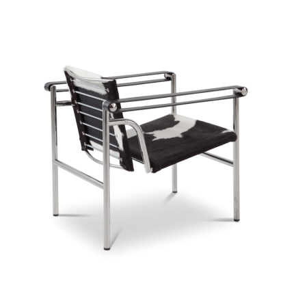 Vue arrière du fauteuil LC1 Cassina en peau tachetée noir et blanc montrant le dossier et la structure chromée