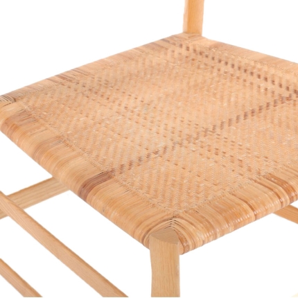 Gros plan sur l'assise cannée et le cadre en bois de la chaise 699 Superleggera Cassina