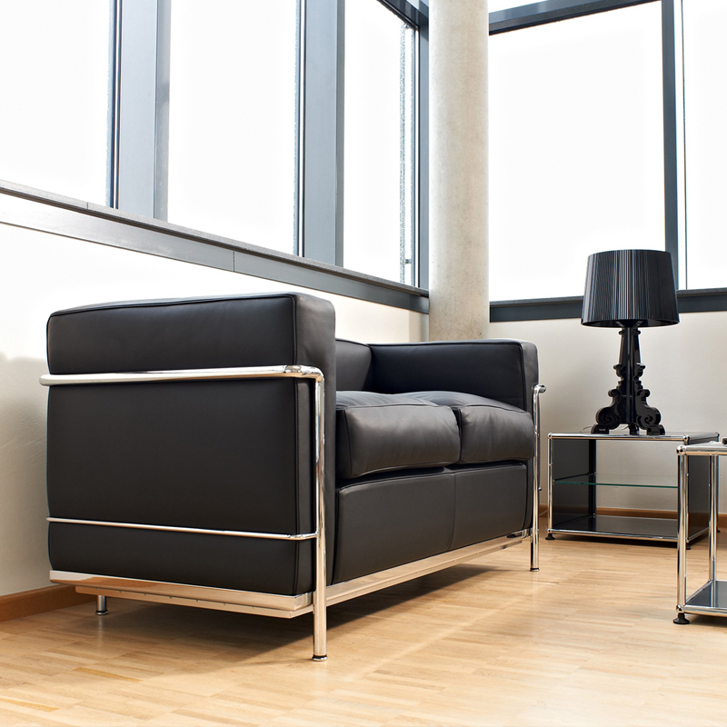 Canapé LC2 Cassina en cuir noir installé devant une fenêtre dans un salon contemporain lumineux
