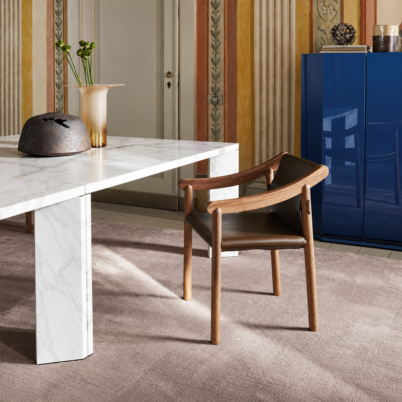 Chaise 905 Cassina en noyer massif et cuir noir près d'une table blanche dans un intérieur avec meuble bleu