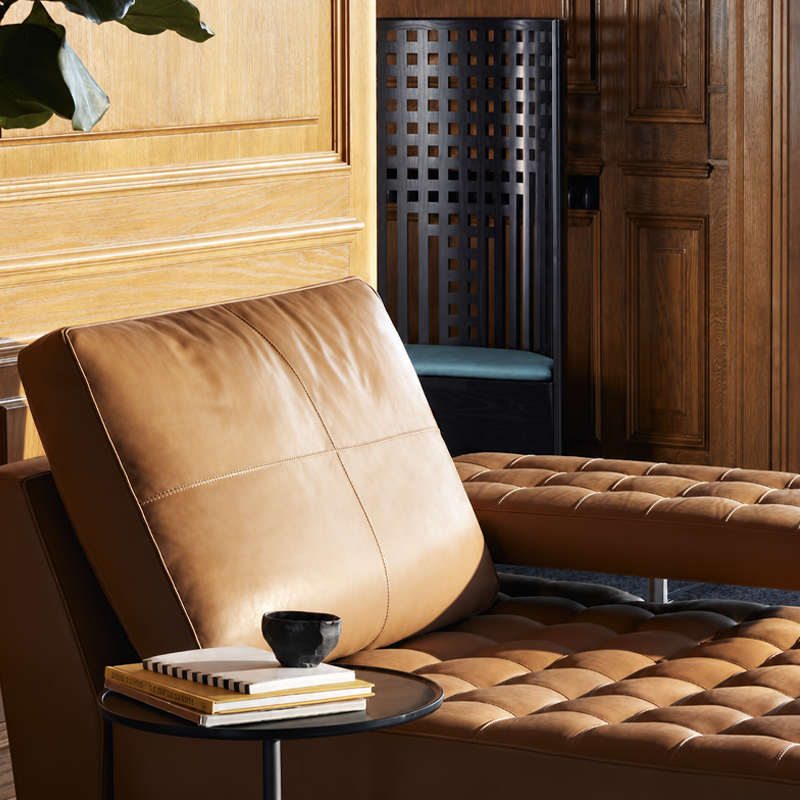 Chaise Hill House 1 de Mackintosh dans un salon contemporain avec canapé en cuir brun et table basse en verre