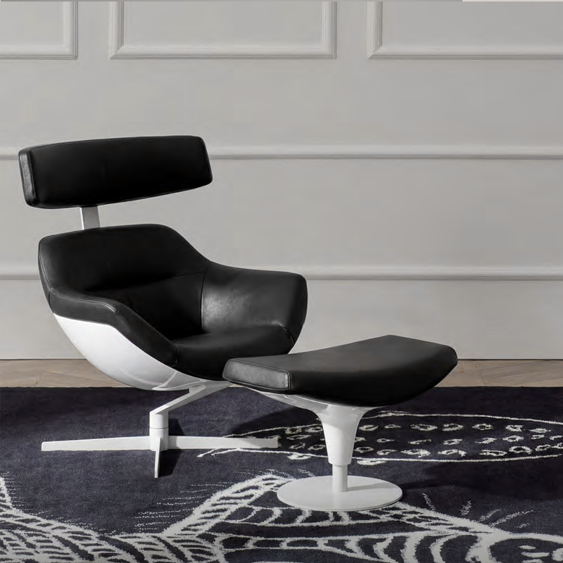 Fauteuil Auckland Cassina noir et blanc accompagné de son repose-pieds sur un tapis graphique dans un salon élégant