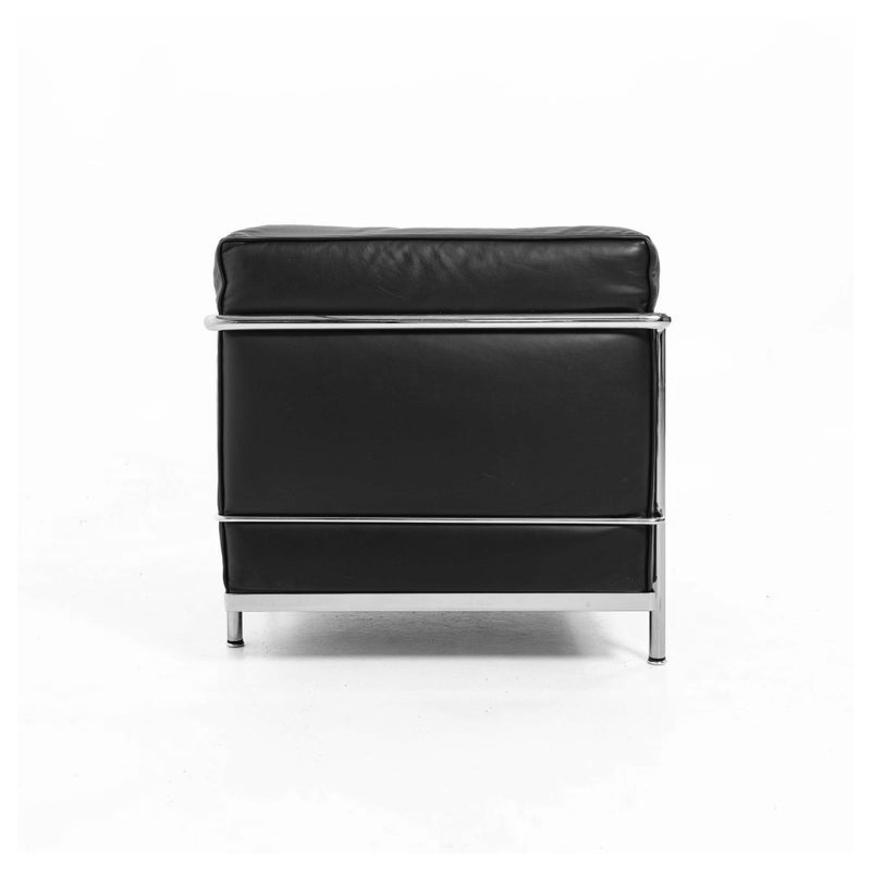Vue arrière du canapé LC2 deux places Cassina avec dossier noir encadré par une structure en acier chromé