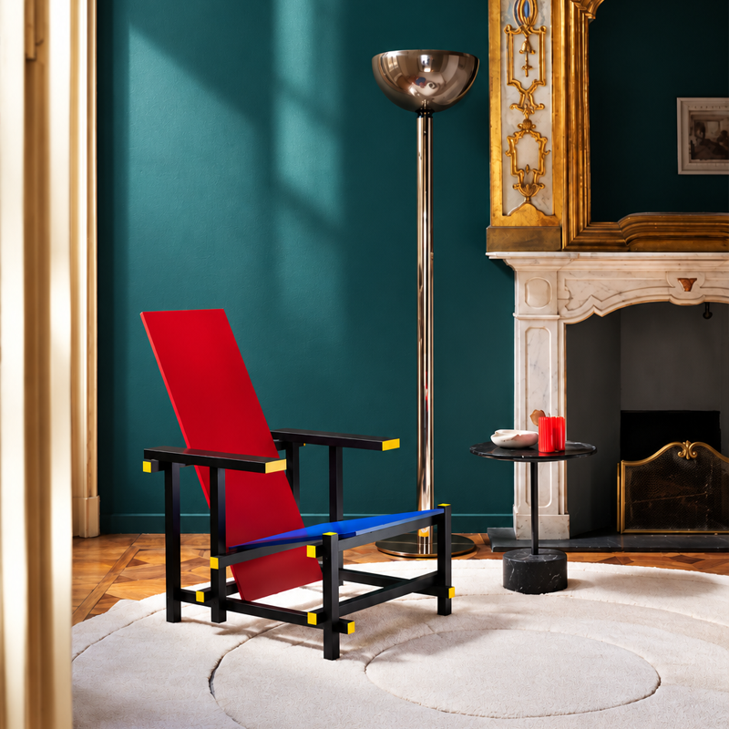 Fauteuil Red and Blue 635 Cassina devant un mur bleu-vert, près d'une cheminée dans un salon élégant