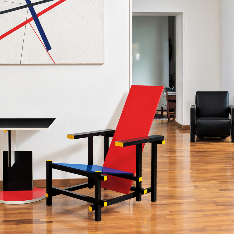 Fauteuil Red and Blue de Gerrit Rietveld installé dans un salon moderne avec parquet et mobilier contemporain