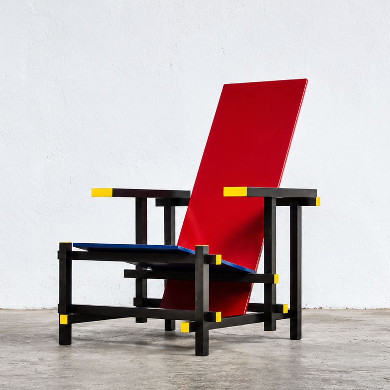 Fauteuil Red and Blue Cassina rouge, bleu et jaune dans un salon contemporain avec œuvres graphiques