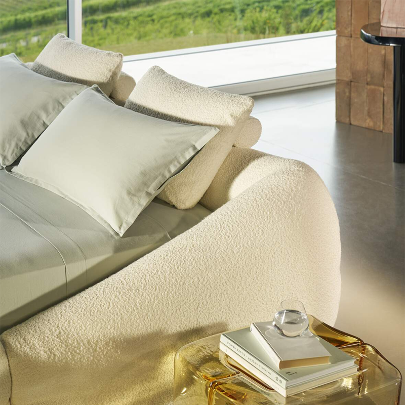 Lit Mon-Nid Cassina en tissu écru dans une chambre contemporaine ouverte sur un paysage verdoyant