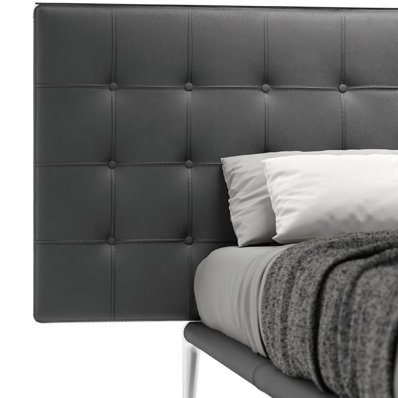 Gros plan sur la tête de lit capitonnée en cuir noir du lit Volage L26 Cassina