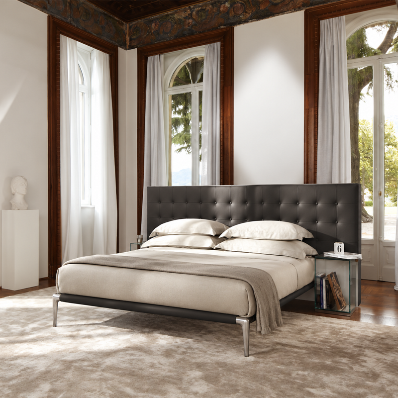 Lit Volage de Philippe Starck avec tête de lit capitonnée dans une chambre élégante aux moulures classiques