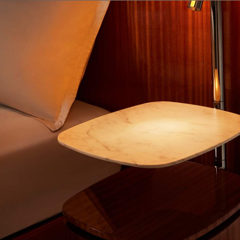 Détail de la table de chevet suspendue en acajou brillant et marbre Calacatta du lit Volage Cassina
