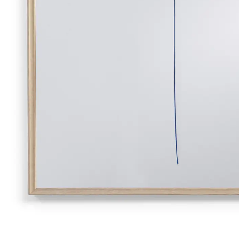 Gros plan sur le trait bleu vertical et le cadre en frêne naturel du miroir Reflections about Spatialism de Ron Gilad