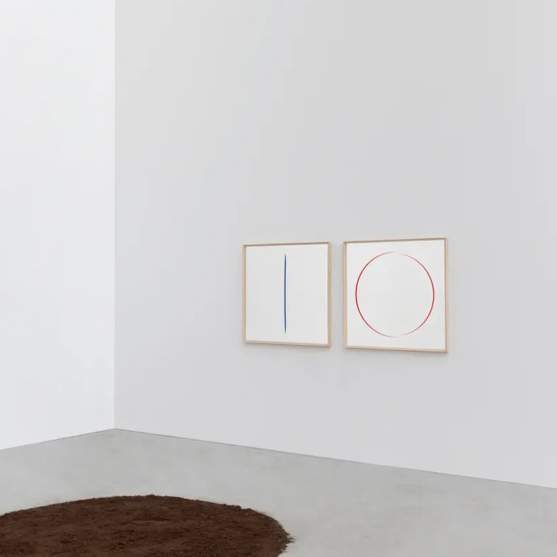 Deux miroirs Deadline de Cassina aux motifs géométriques bleu et rouge sur un mur blanc minimaliste