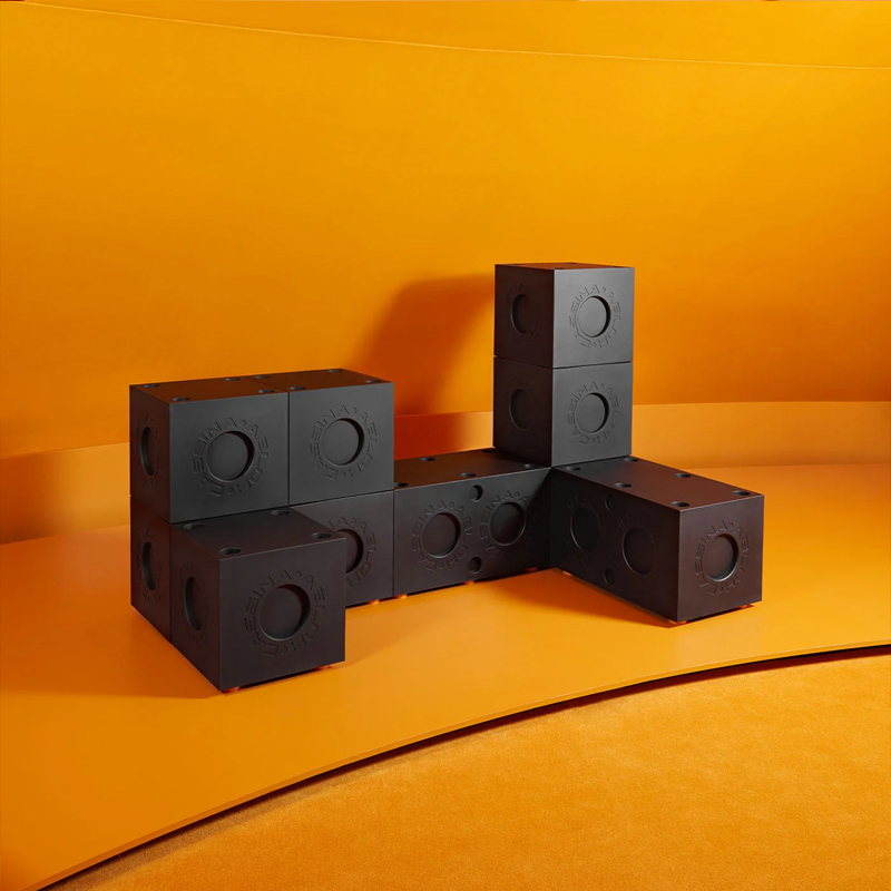 Composition de cubes Modular Imagination Cassina noirs, assemblés en différentes configurations sur fond orange