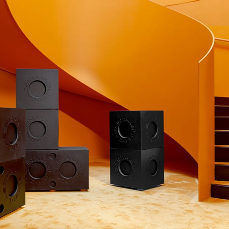 Plusieurs modules Modular Imagination Cassina noirs disposés dans un intérieur aux tonalités orange
