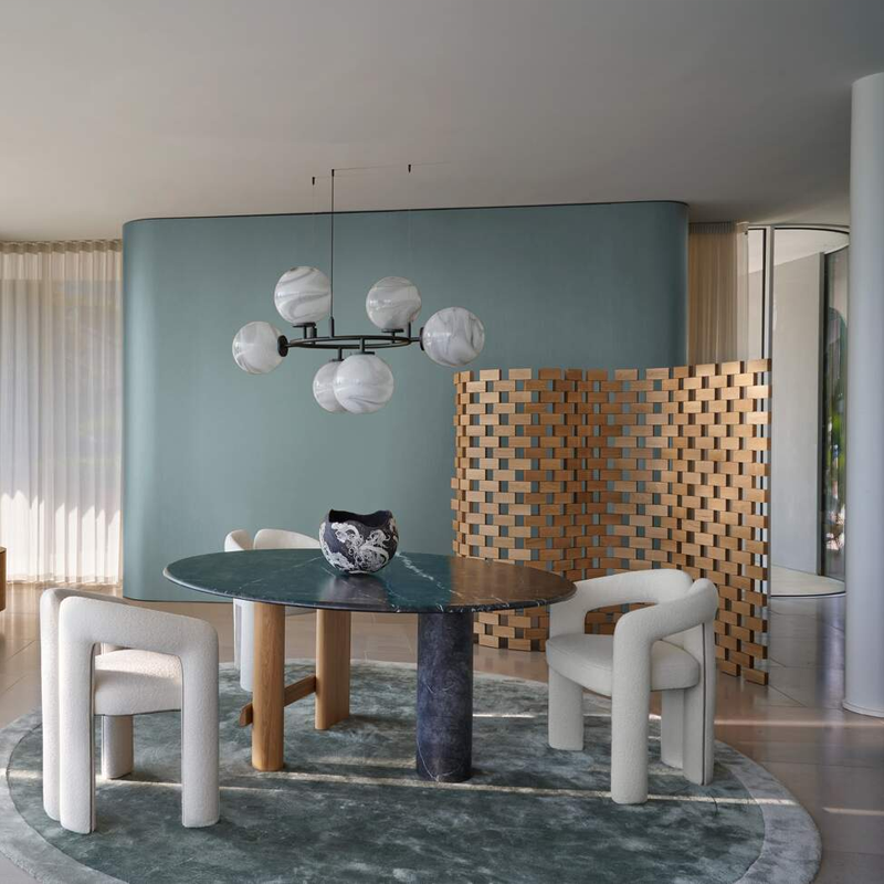 Paravent Ambassade 537 en noyer Canaletto dans une salle à manger contemporaine avec table ronde et fauteuils rouges