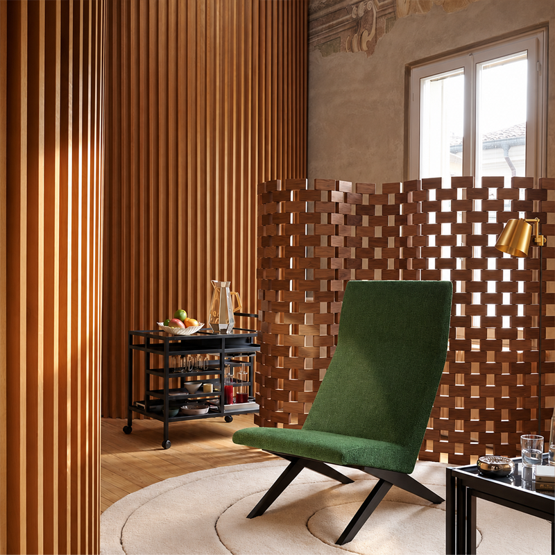 Paravent Ambassade 537 Cassina en noyer naturel près d'un fauteuil vert dans un salon chaleureux aux boiseries verticales