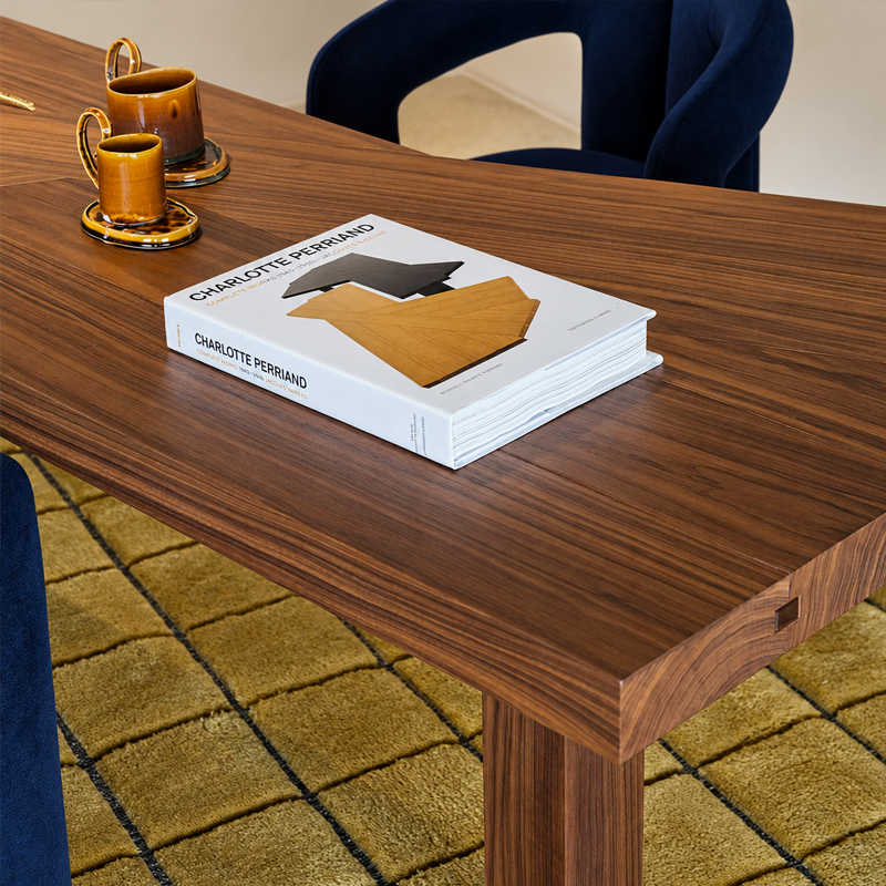 Gros plan sur le plateau en noyer Canaletto naturel de la table Ventaglio Cassina avec livres et objets décoratifs