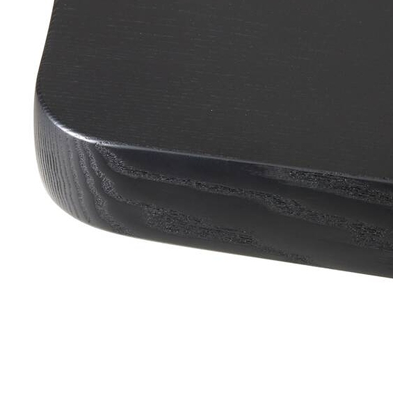 Détail du chant arrondi et du veinage du plateau en frêne massif teinté noir de la table Montparnasse Cassina
