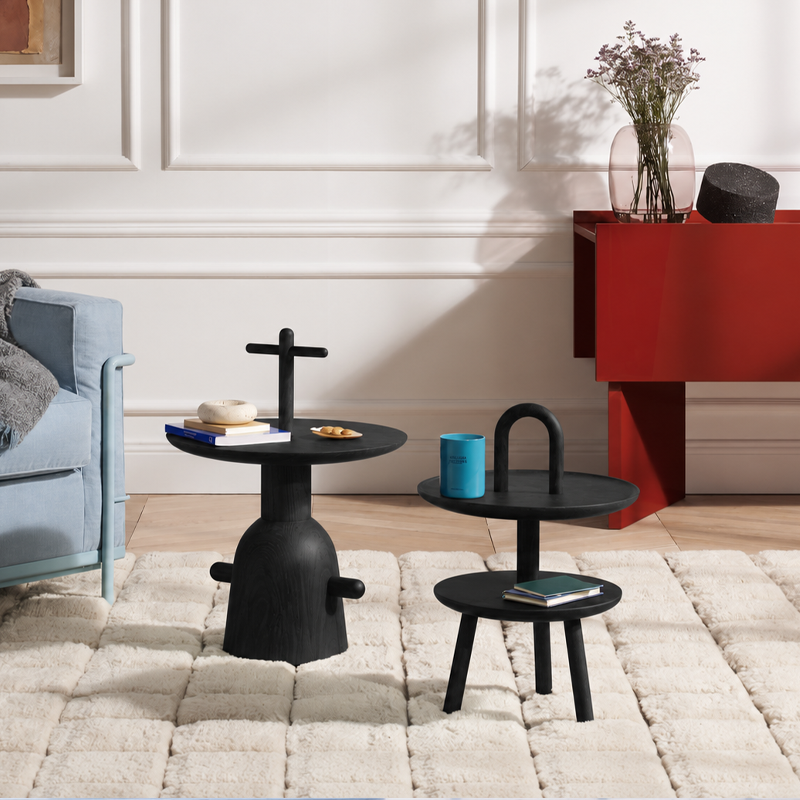 Composition de tables Réaction Poétique Cassina en frêne noir près d'un canapé et d'un meuble rouge