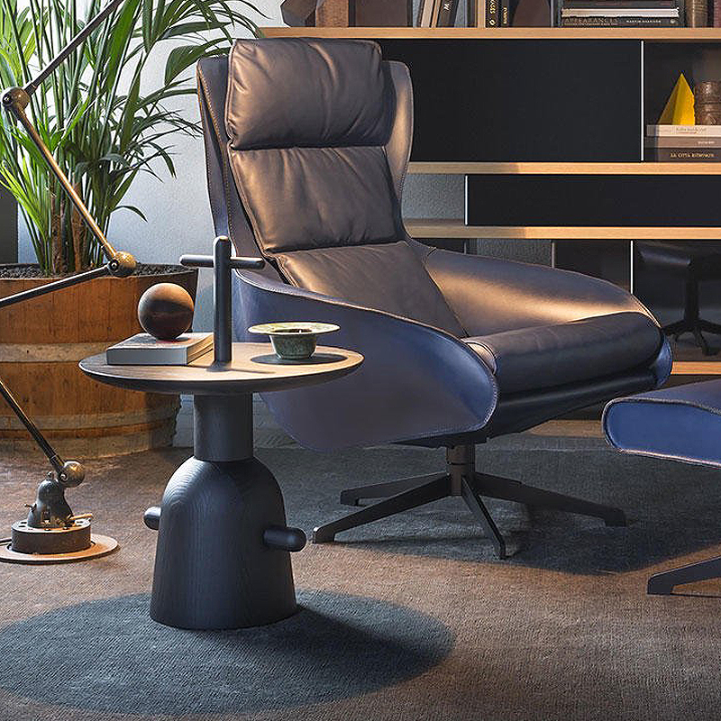 Table d'appoint Réaction Poétique noire de Cassina près d'un fauteuil relax en cuir dans un coin lecture