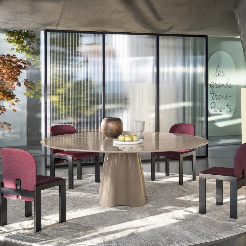 Table ronde Treflo beige de Ronan Bouroullec entourée de chaises bordeaux dans une salle à manger contemporaine